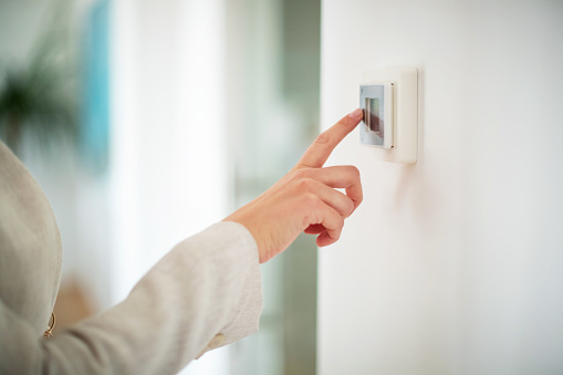 Hand on light switch with index finger