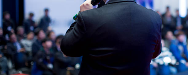 istock Speaker at Talk in Business Conference. Executive Speaker Entrepreneur on Stage Conference Photo. Business Presentation Presenter Speech at Tech Meeting. Corporate Forum Event for Investor Audience. 1139848683