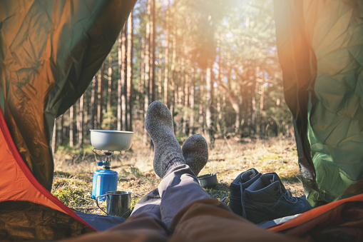 wanderlust outdoor camping - traveler feet out of the tent