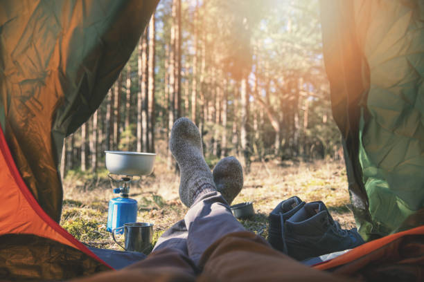 wanderlust outdoor camping - traveler feet out of the tent - tree area footpath hiking woods imagens e fotografias de stock