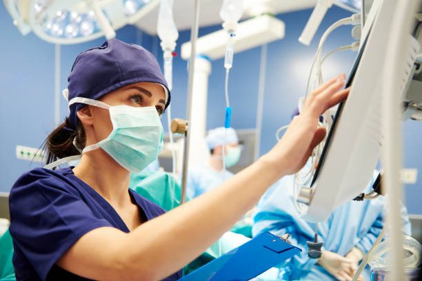 enfermera que trabaja con tecnología en quirófano - surgeon hospital surgery doctor fotografías e imágenes de stock