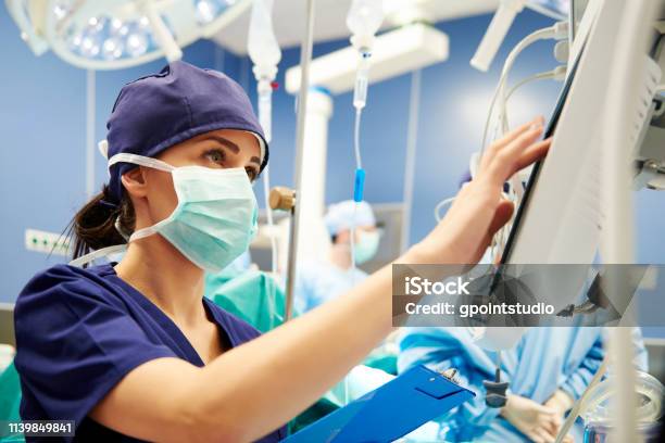 Nurse Working With Technology In Operating Room Stock Photo - Download Image Now - Nurse, Hospital, Healthcare And Medicine