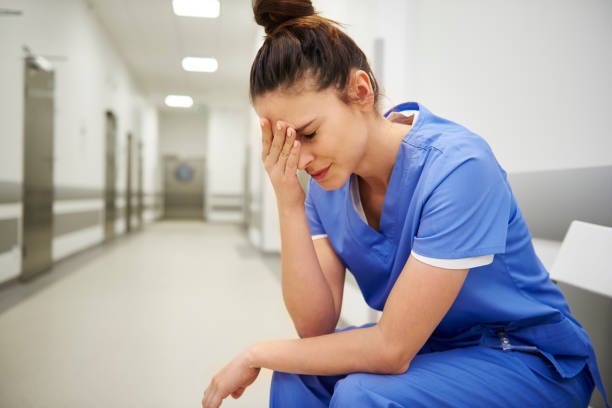 медсестра-женщина, страдающая головной болью - doctor tired protective workwear sadness стоковые фото и изображения