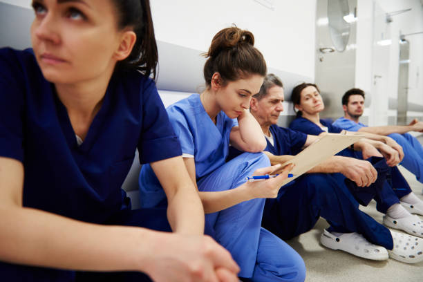 female nurse examining medical records in the corridor - nurse hygiene emotional stress surgeon imagens e fotografias de stock