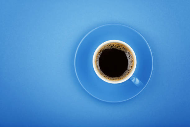 Coffee beans, ice cubes and white and blue paper drinking straws pattern on pastel blue background. Summer drink minimal concept. Flat lay composition.