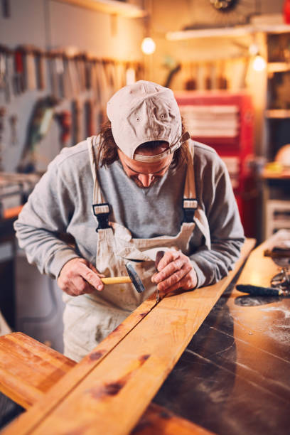 istock Male carpenter fixing old wood in a retro vintage workshop. 1139856262