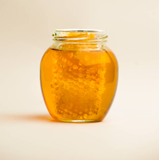 istock A jar of honey with a honeycomb 1139858756