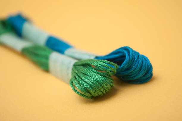 istock colorful cotton threads on yellow background 1139861719