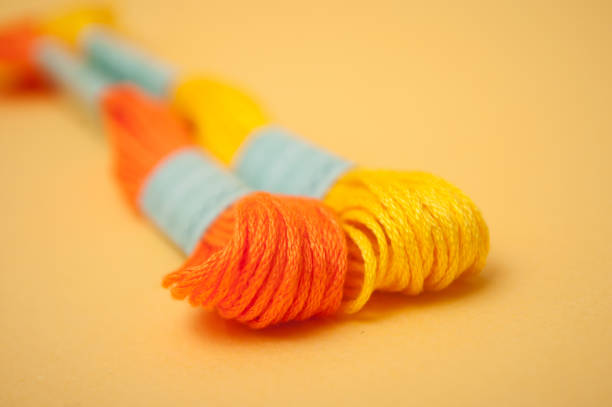 istock colorful cotton threads on yellow background 1139861931