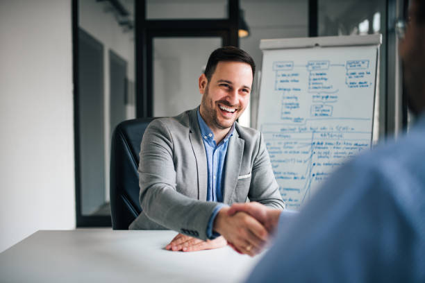 istock Good deal. Two business people shaking hands while sitting at the working place. 1139862050