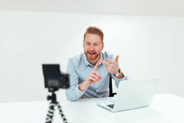 istock Young redhead man recording video for his vlog in bright space. 1139863504