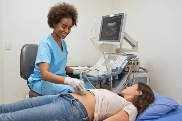 istock Smiling female nurse examining patient's stomach 1139863539