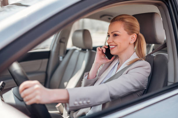 istock Smiling female executive talking on mobile phone and driving. 1139863598