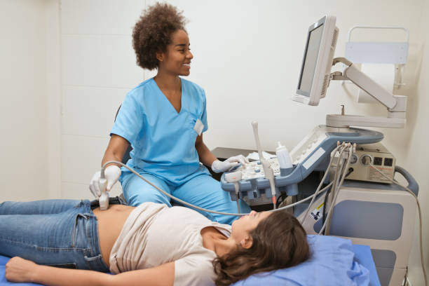 istock Smiling female nurse scanning woman's stomach 1139863884