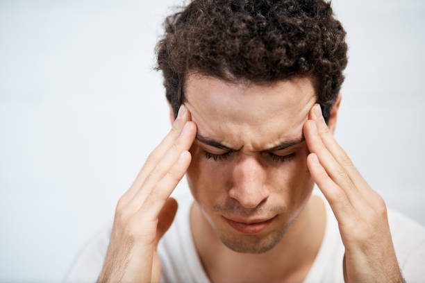 istock Young man frowns, holding head 1139865665