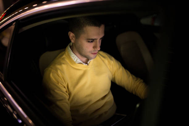 istock Man in the back seat is doing work on his laptop 1139868265
