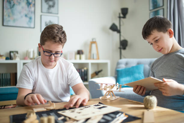 istock Brothers making wooden model plane for school project 1139872318