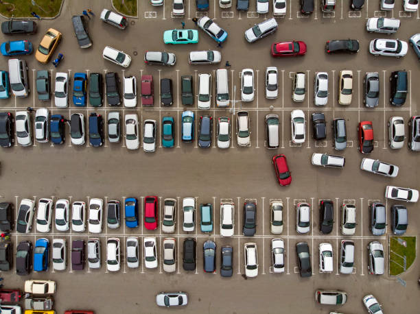 vue d’en haut sur les lignes de voitures stationnées. trafic lourd dans le parking. recherche d’espaces dans le parc de véhicules occupés. croisière pour le stationnement dans le dortoir. pénurie d’espace pour l’automobile. - mannered photos et images de collection