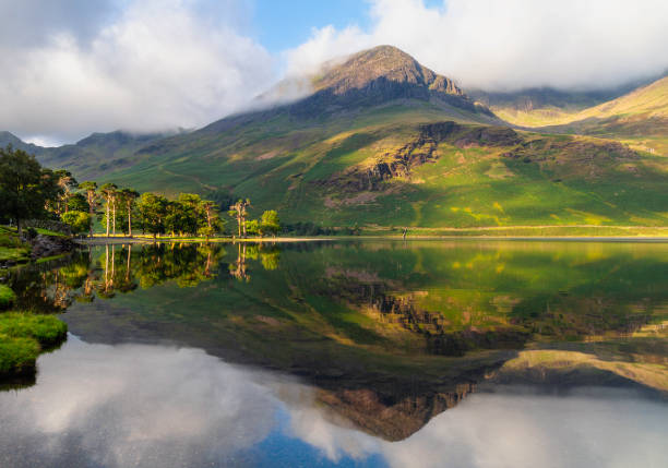 Buttermere In The English Lake District Dawn breaks over Buttermere, in the English Lake District. english lake district stock pictures, royalty-free photos & images