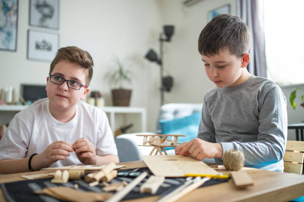 istock Brothers making wooden model plane for school project 1139872559
