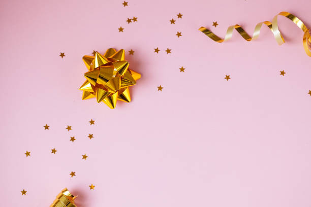 istock Golden decorations and sparkles on pink background 1139872897