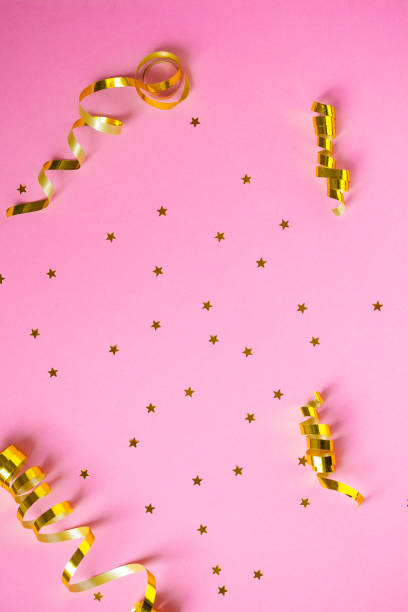 istock Golden decorations and sparkles on pink background 1139873408