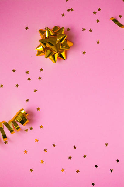 istock Golden decorations and sparkles on pink background 1139873466