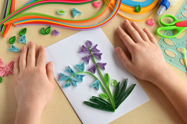 istock Quilling technique. Making decorations or greeting card. Paper strips, flower, scissors. Handmade crafts on holiday: Birthday, Mother's or Father's Day, March 8, Wedding. Children's DIY concept. 1139873678