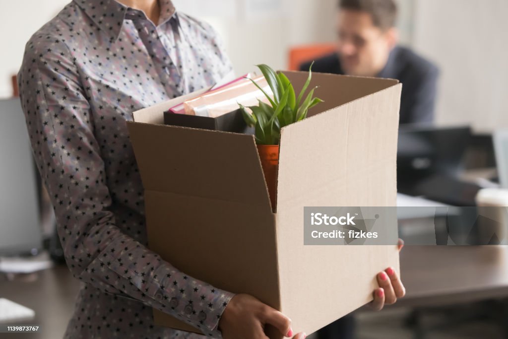 Close up view of new female employee intern holding box Close up view of new female employee intern holding cardboard box with belongings start finish job in company office, busnesswoman newcomer worker get hired fired on first last day at work concept Quitting a Job Stock Photo