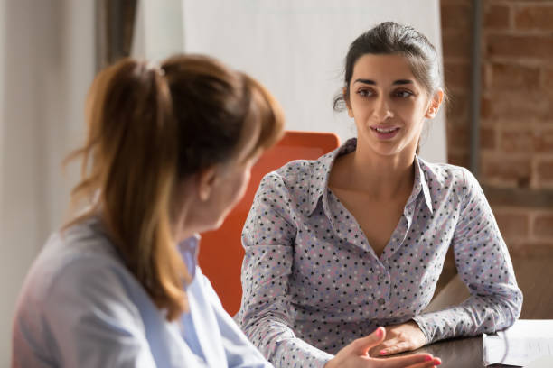 mujer de negocios indio hablando cliente de consultoría en la reunión de oficina comercial - chat dar fotografías e imágenes de stock