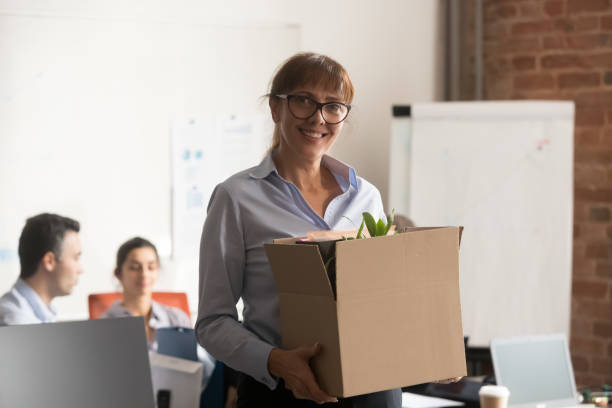 istock Smiling middle aged businesswoman holding box looking at camera 1139873785