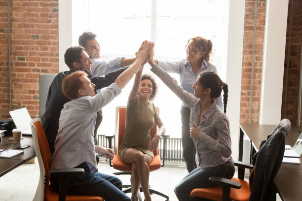 Motivated happy diverse office people group giving high five Motivated happy diverse business office people employees group give high five with coach mentor engaged in team win result promise support integrity in teamwork, celebrate cooperation reward concept high fidelity stock pictures, royalty-free photos & images