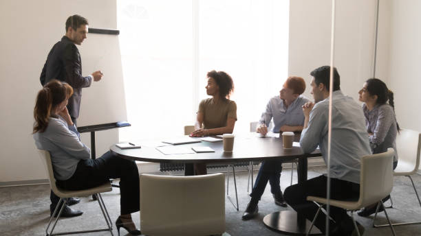 istock Businessman coach giving presentation on whiteboard at team business training 1139873839