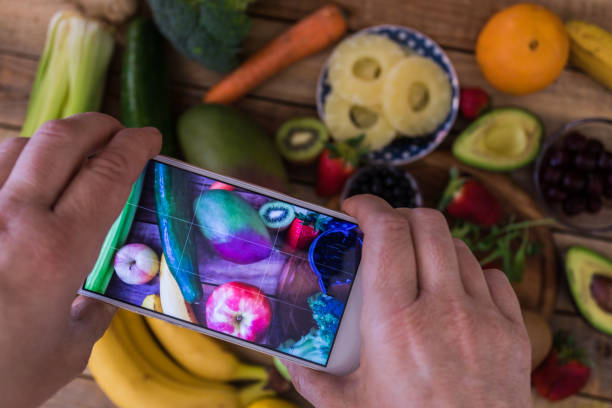 istock Fruit and veggies assortment at wood table, shot from above using smartphone 1139874036