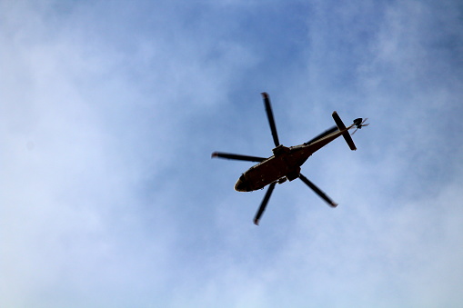 silhouette of helicopter high in the sky