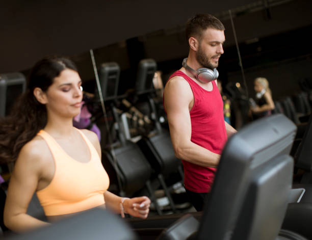 istock Young couple running on treadmills in modern gym 1139884247
