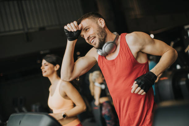 istock Young couple running on treadmills in modern gym 1139884255