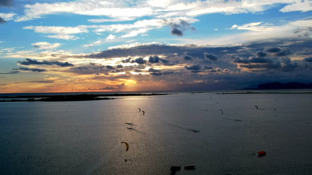 Hang-gliders flying above coast. Sea sunset. Aerial view