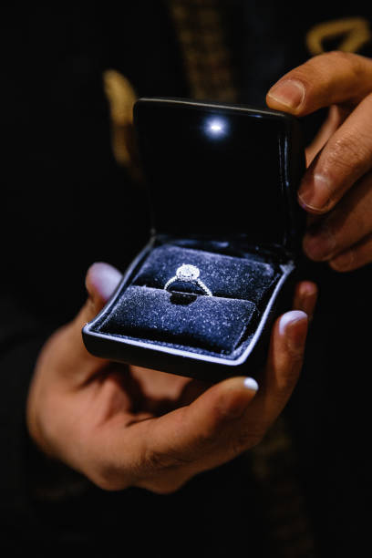 istock Real life proposal: Man holds an illuminated engagement ring - Blue bride ring with a big gem 1139889844