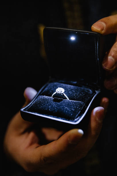 istock Real life proposal: Man holds an illuminated engagement ring - Blue bride ring with a big gem 1139890404