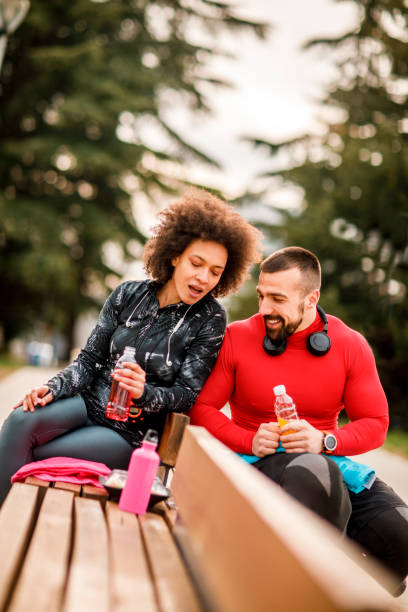 istock Young athletic couple hydrating themselves while taking a break after exercising in a city park 1139890829