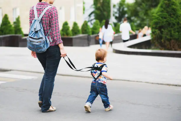 Photo of Mom insures her child during a walk