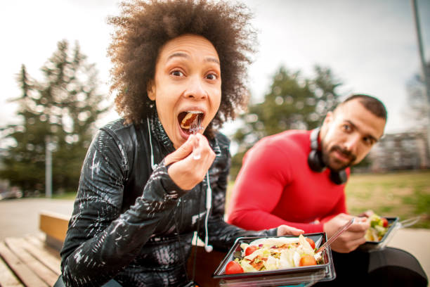 istock Young couple having a protein salad while sitting next to each other on a park bench 1139892309