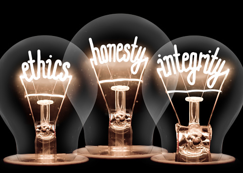 Photo of light bulbs with shining fibres in ETHICS, HONESTY and INTEGRITY shape isolated on black background