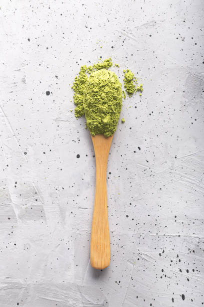 istock Green tea matcha in a spoon on concrete surface. Close up shot 1139893925