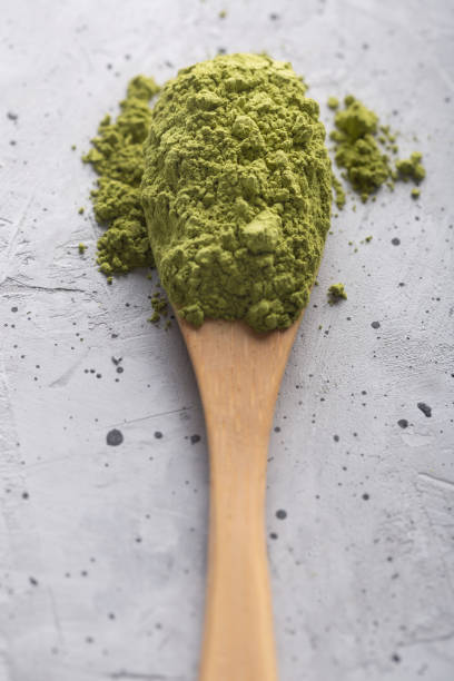 istock Green tea matcha in a spoon on concrete surface. Close up shot 1139893929