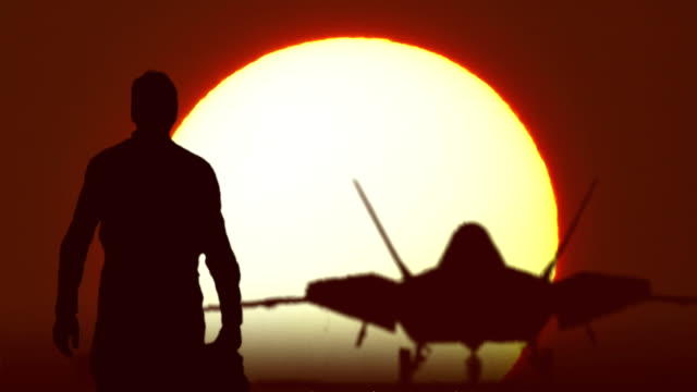 F22 fighter pilot walks against sunrise.mov
