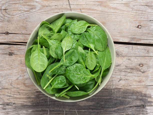 istock Fresh spinach leaves in bowl on rustic wooden table 1139896130