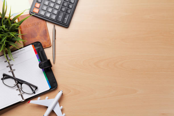 Business trip concept. Accessories on desk table. Glasses, passport, notepad, calculator and airplane toy. Top view with copy space