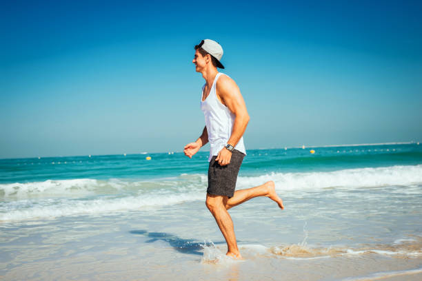 enjoying the magic of running trough the water! - swimming shorts shorts swimming trunks clothing imagens e fotografias de stock